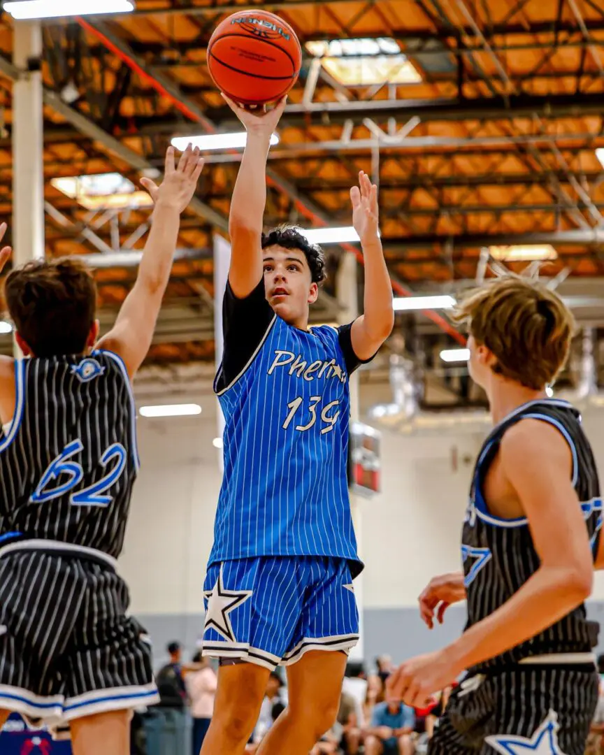 Teen shoots basketball in game.