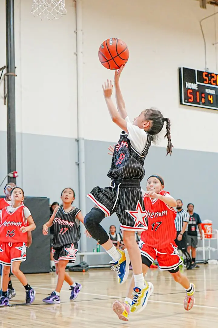 Girl shooting basketball in game.