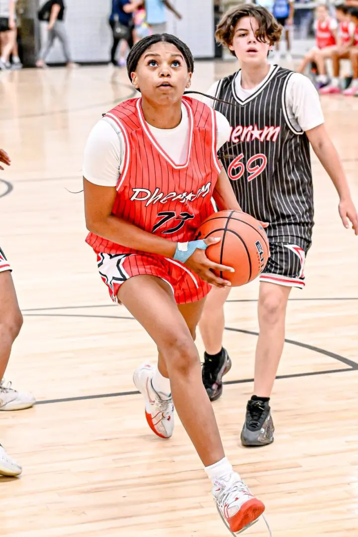 Girl dribbling basketball during game.