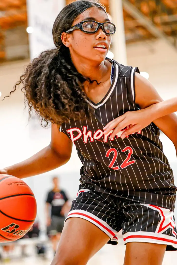 Girl dribbling basketball, number 22.