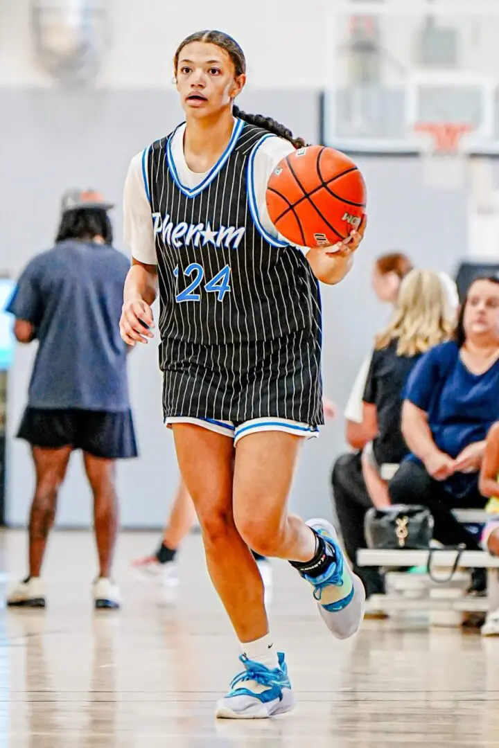 Girl dribbling basketball, number 24.