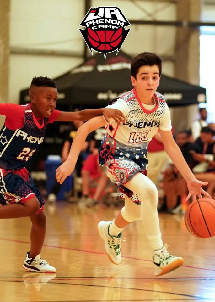 Two boys playing intense youth basketball.