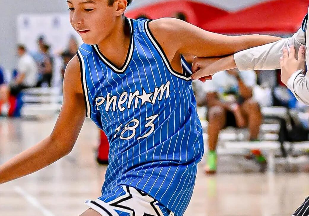Basketball player dribbling past a defender.