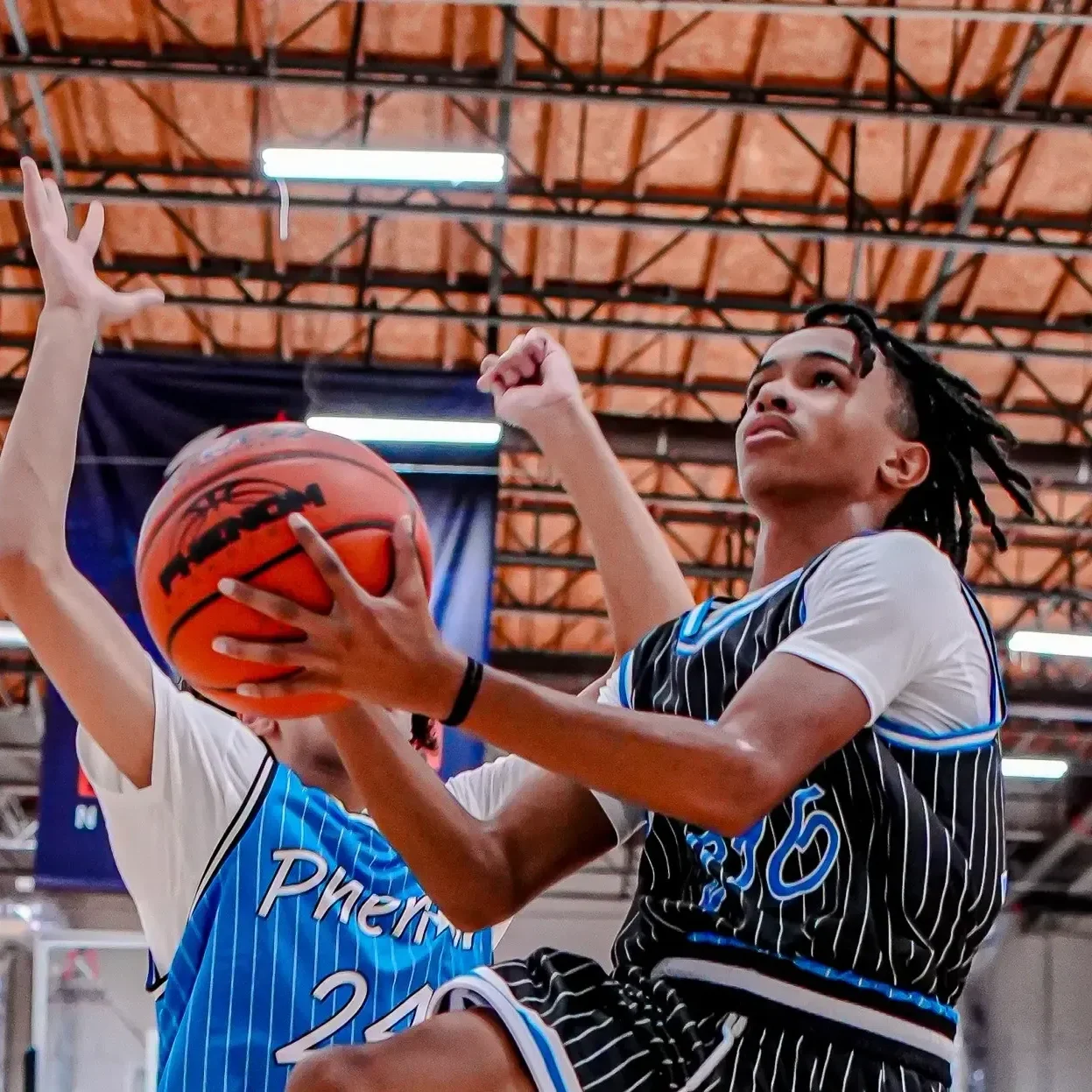 Young basketball player aiming for a shot during a game.